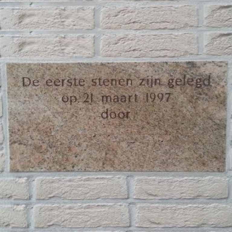 Gegraveerde eerste steen in de gevel