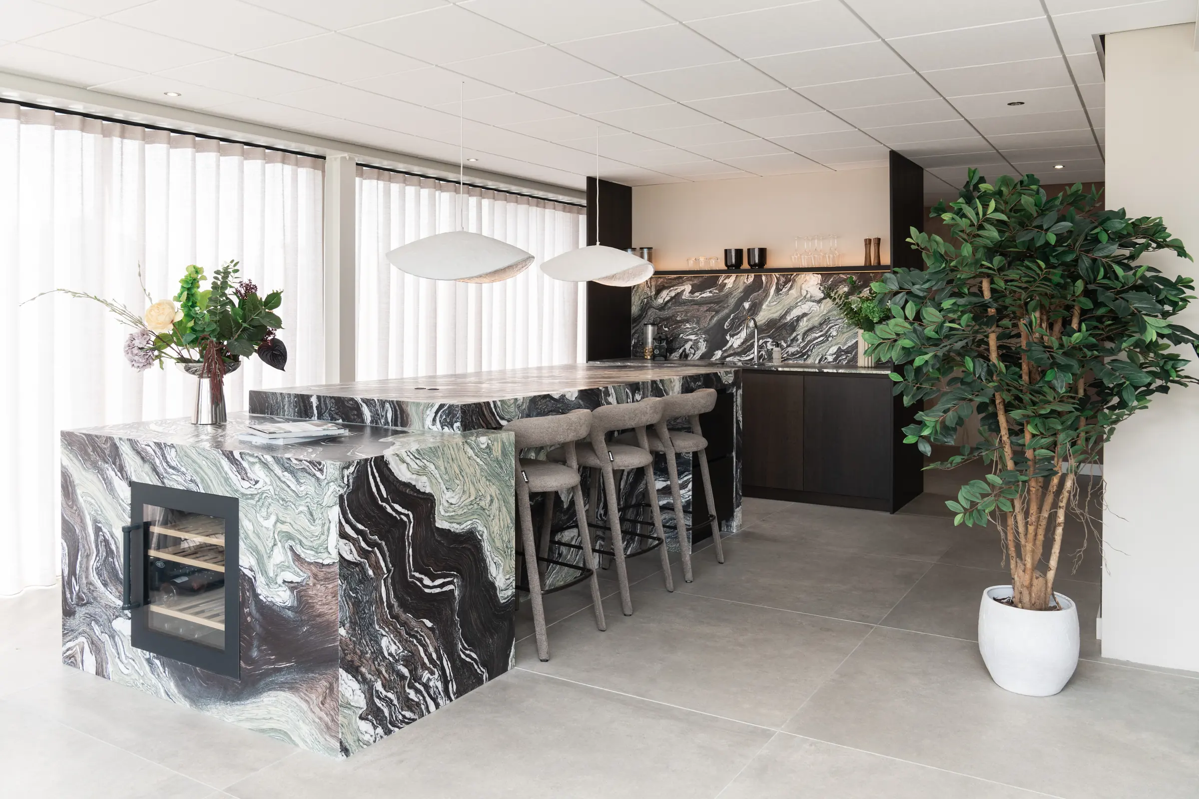 Kookeiland in natuursteen met wijnklimaatkast in de showroom van Wagemaker Marmer & Graniet in Middelharnis