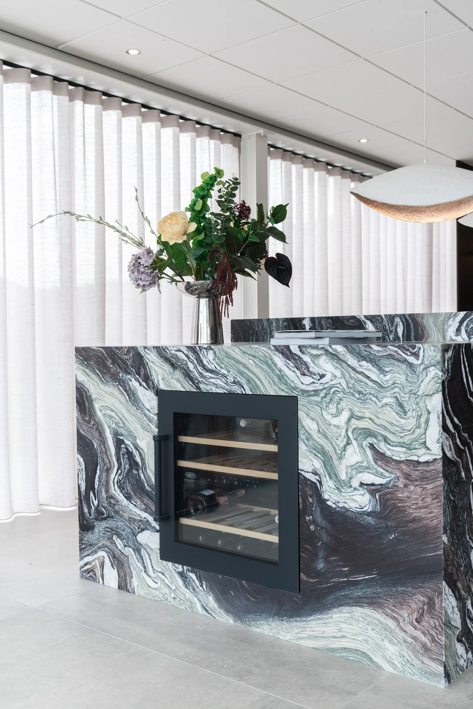 Zijkant van het natuurstenen kookeiland met wijnklimaatkast in de showroom van Wagemaker Marmer & Graniet in Middelharnis