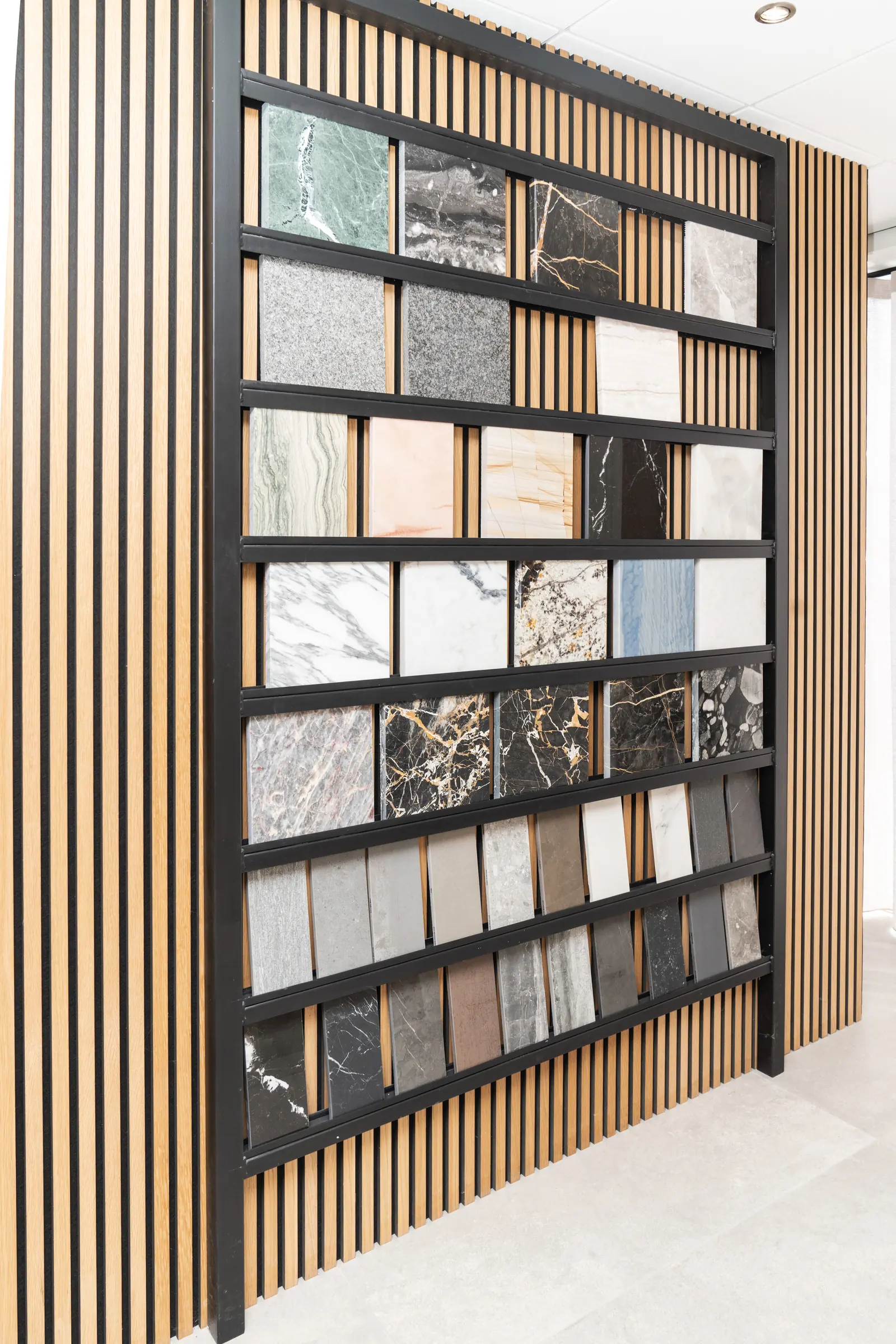 Stalenwand met natuursteen tussen houten lamellen in de showroom van Wagemaker Marmer & Graniet in Middelharnis